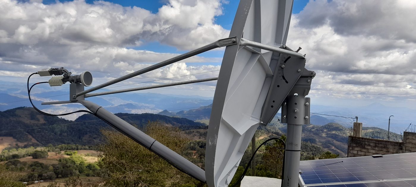 Antena VSAT instalada en zona montañosa junto a panel solar