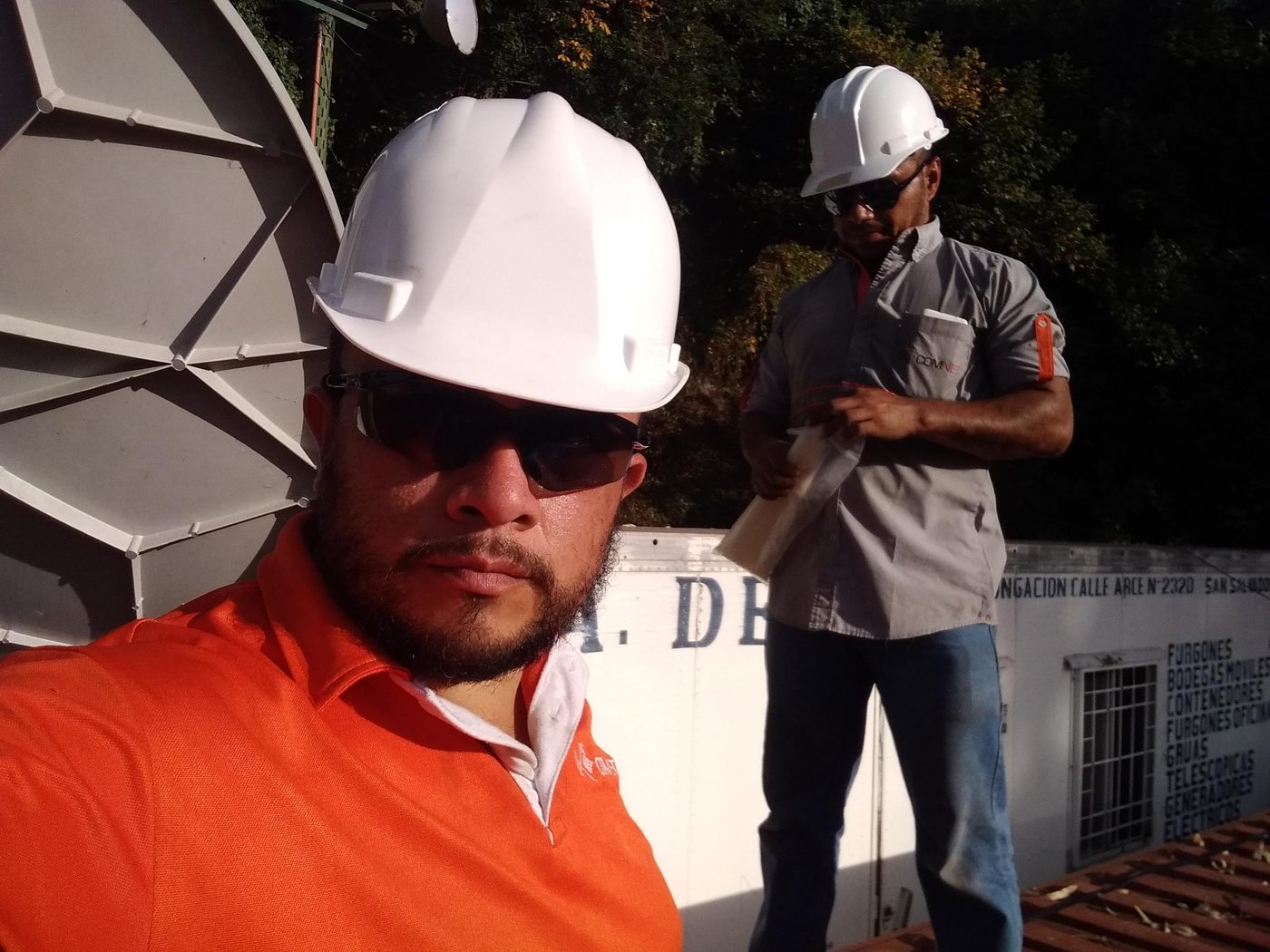 Francisco Maldonado con antena VSAT hexagonal, equipo de trabajo